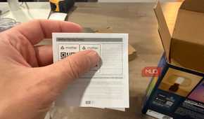 Hand holding the Matter pairing codes card from the packaging