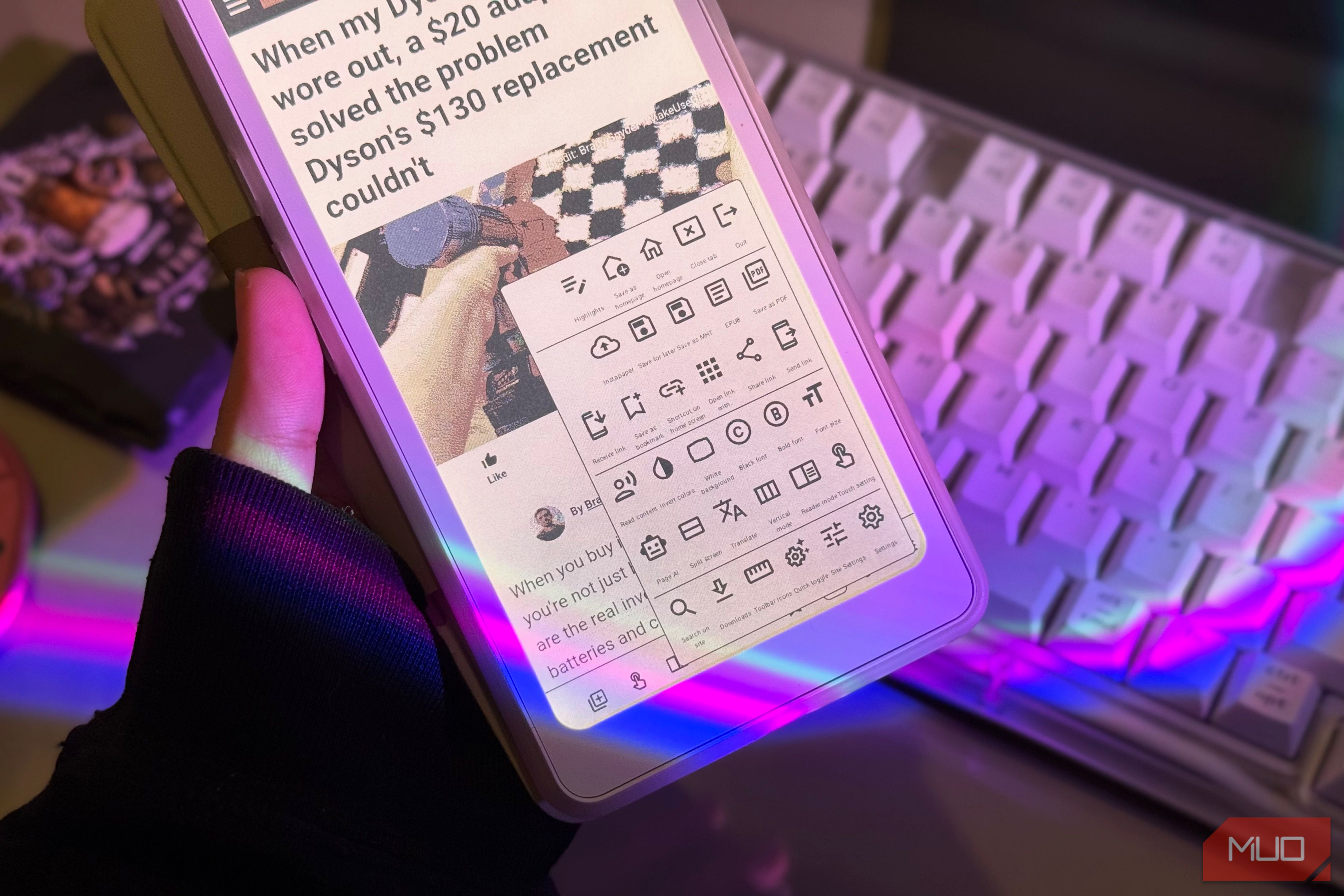 Hand holding the Palma 2 Pro with EinkBro toolbar menu open above a keyboard