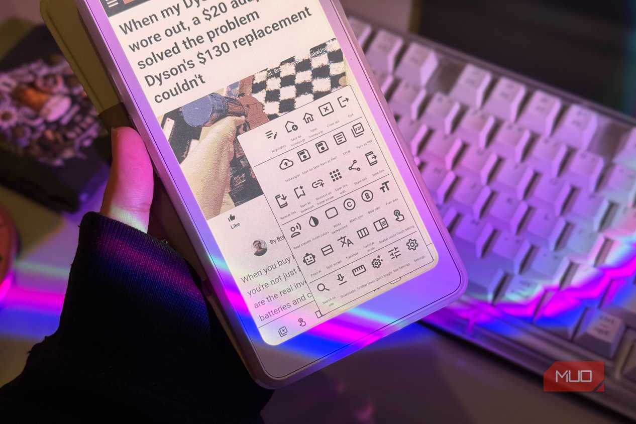 Hand holding the Palma 2 Pro with EinkBro toolbar menu open above a keyboard