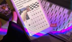 Hand holding the Palma 2 Pro with EinkBro toolbar menu open above a keyboard