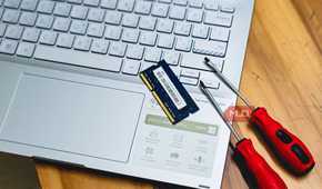 laptop ram memory upgrade with screwdrivers on wooden desk