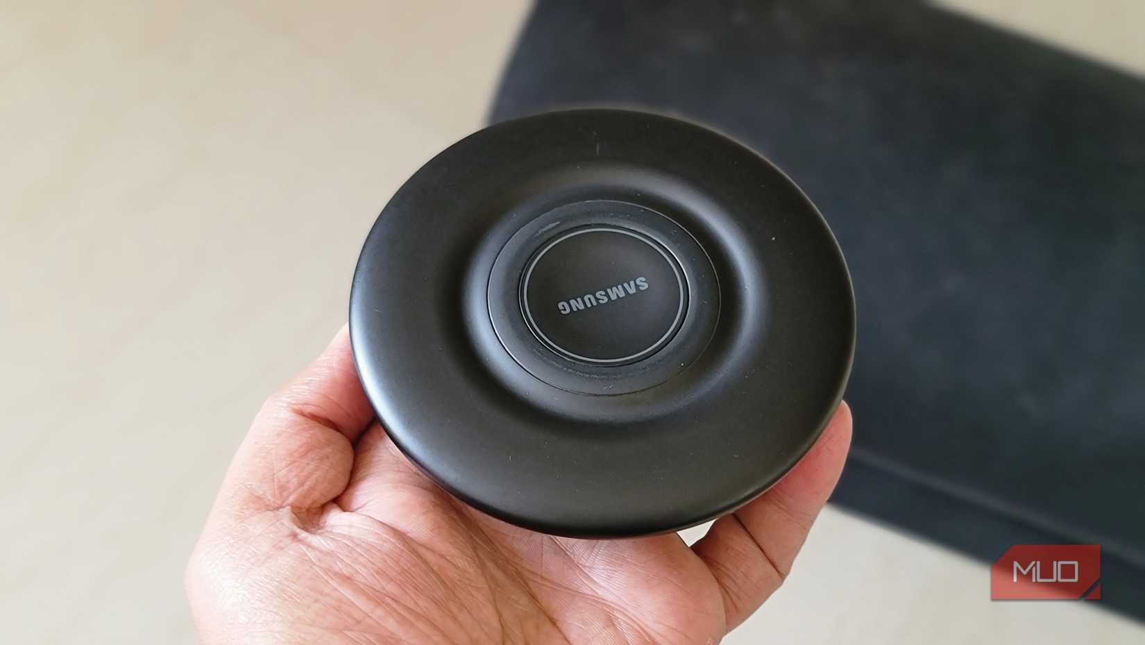 samsung black wireless charging pad in hand