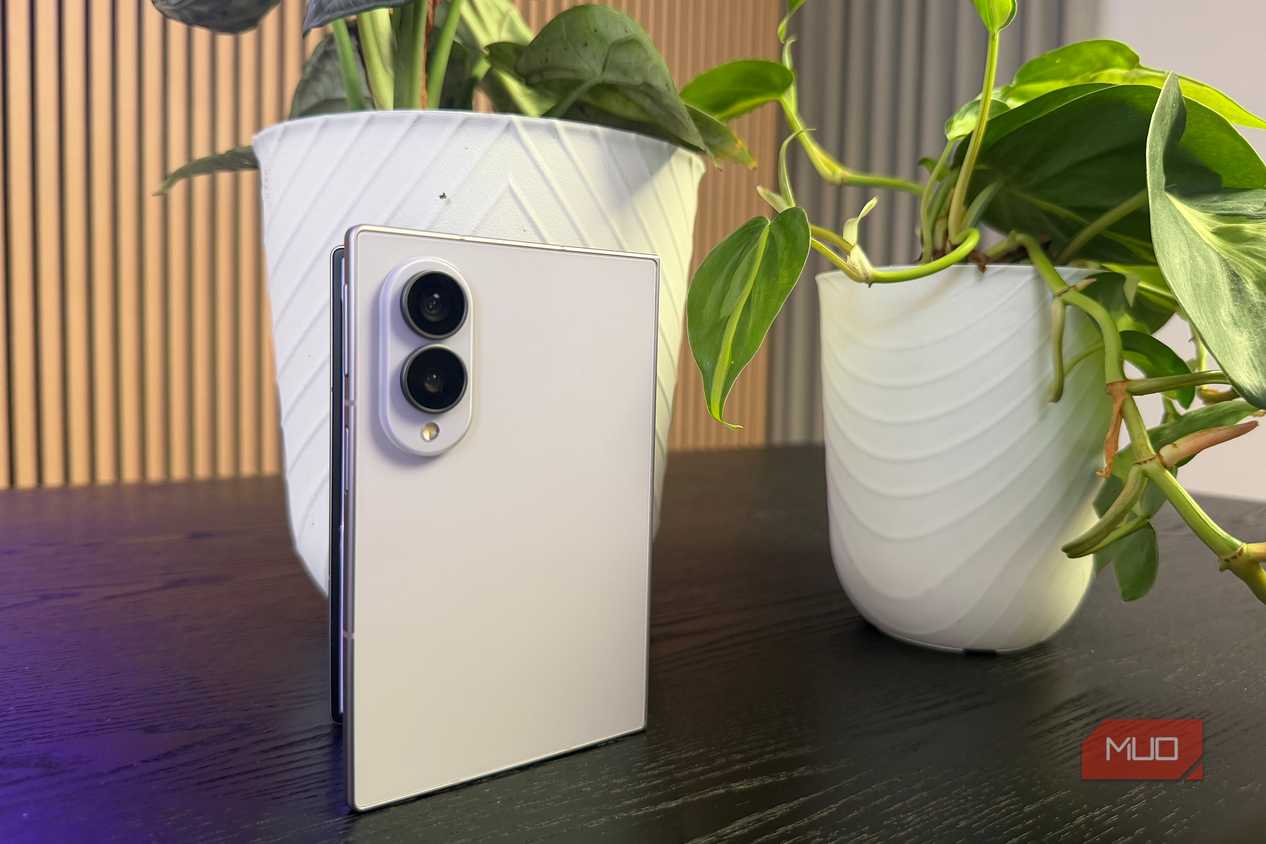 The Samsung Galaxy Z Fold 8 leaning up against a plant.