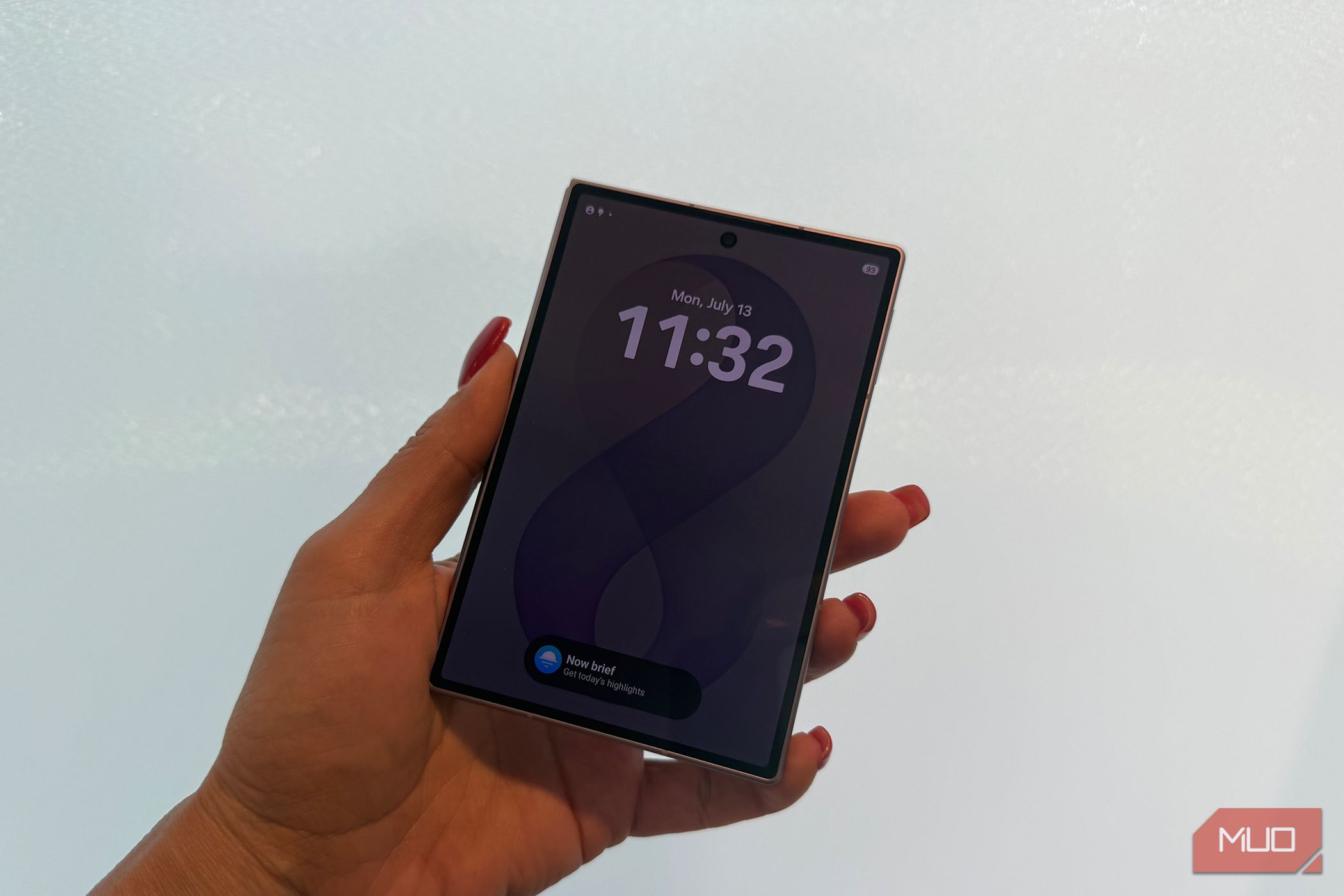 The Samsung Galaxy Z Fold 8 in hand closed in front of a white wall.