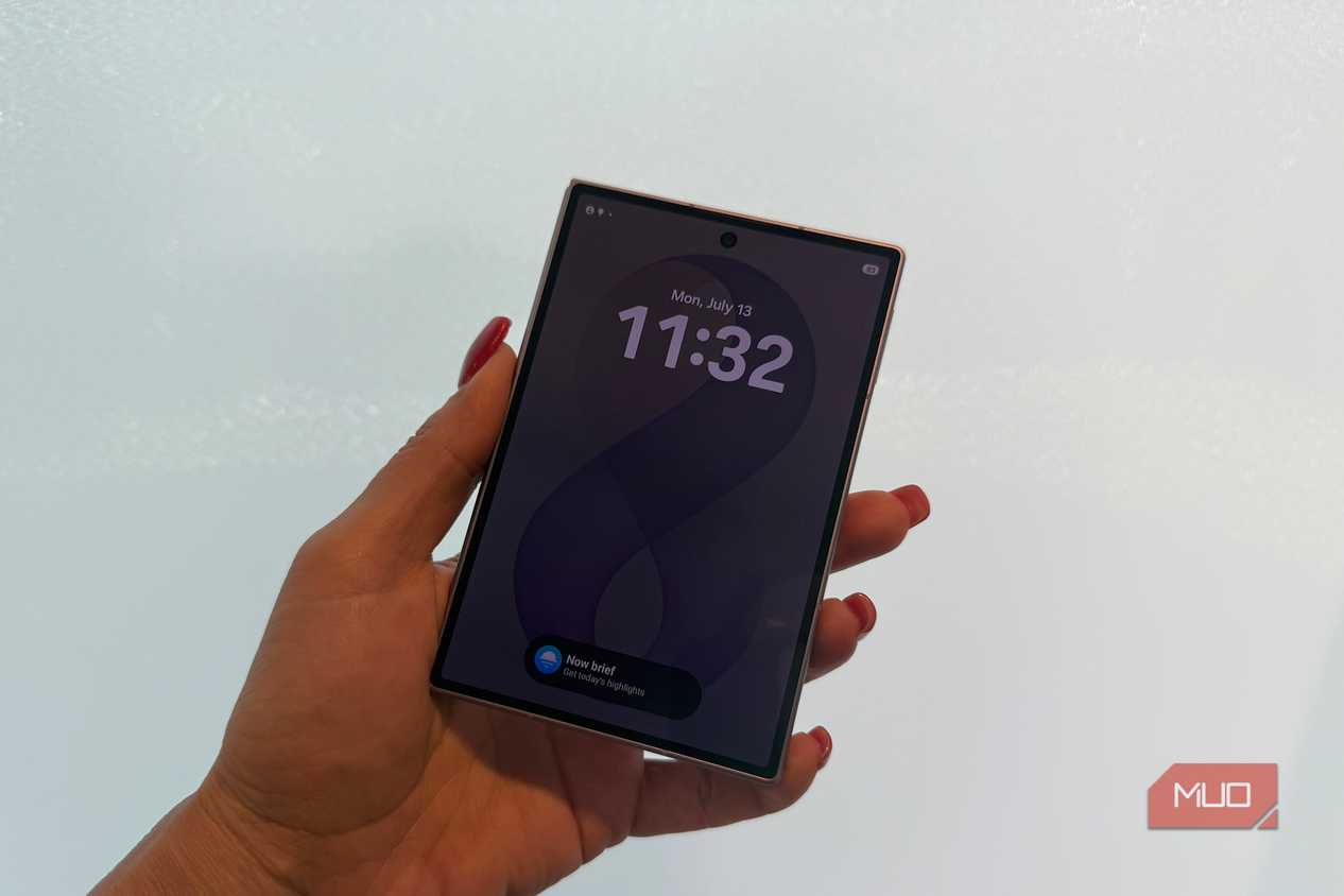 The Samsung Galaxy Z Fold 8 in hand closed in front of a white wall.