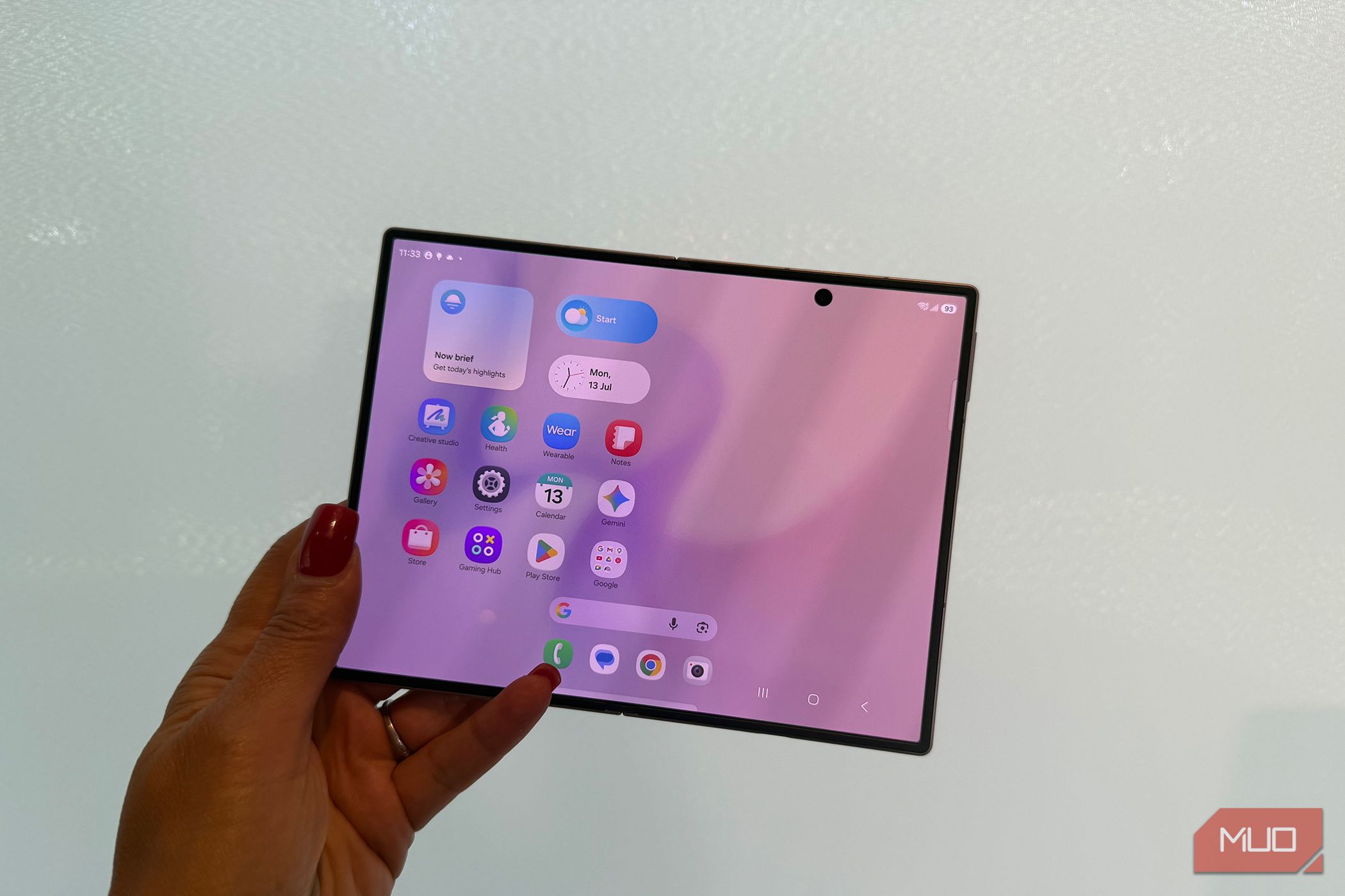 The Samsung Galaxy Z Fold 8 in hand open in front of a white wall.