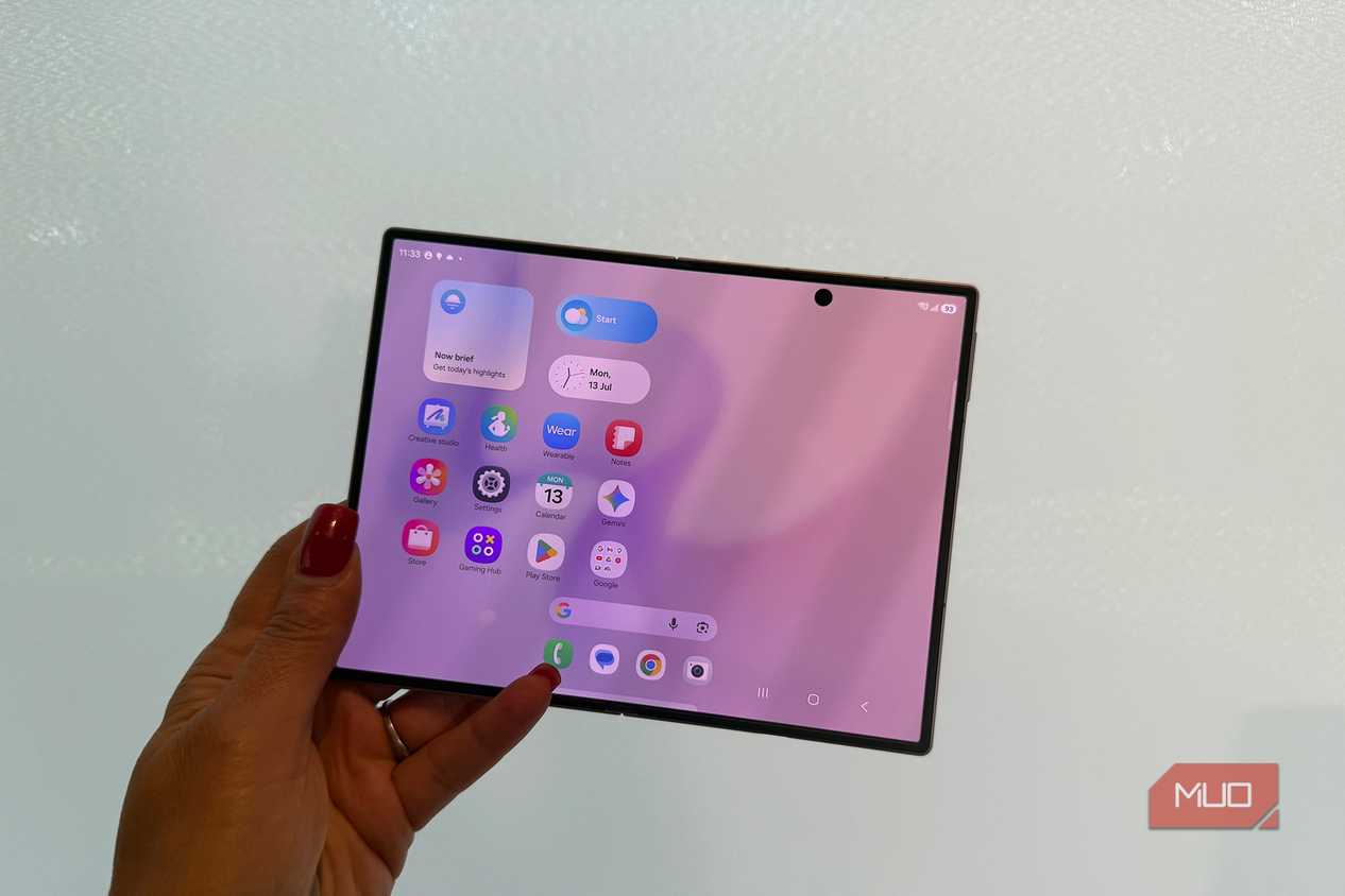 The Samsung Galaxy Z Fold 8 in hand open in front of a white wall.