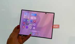 The Samsung Galaxy Z Fold 8 in hand open in front of a white wall.