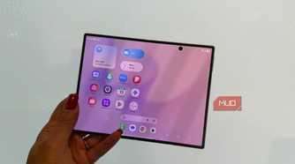 The Samsung Galaxy Z Fold 8 in hand open in front of a white wall.