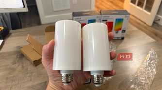 Two Linkind Smart Light Stick bulbs held in hand showing E26 base