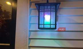 Wall lantern glowing in mixed colors with a Linkind smart bulb 2