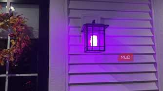 Wall lantern glowing purple with a Linkind smart bulb