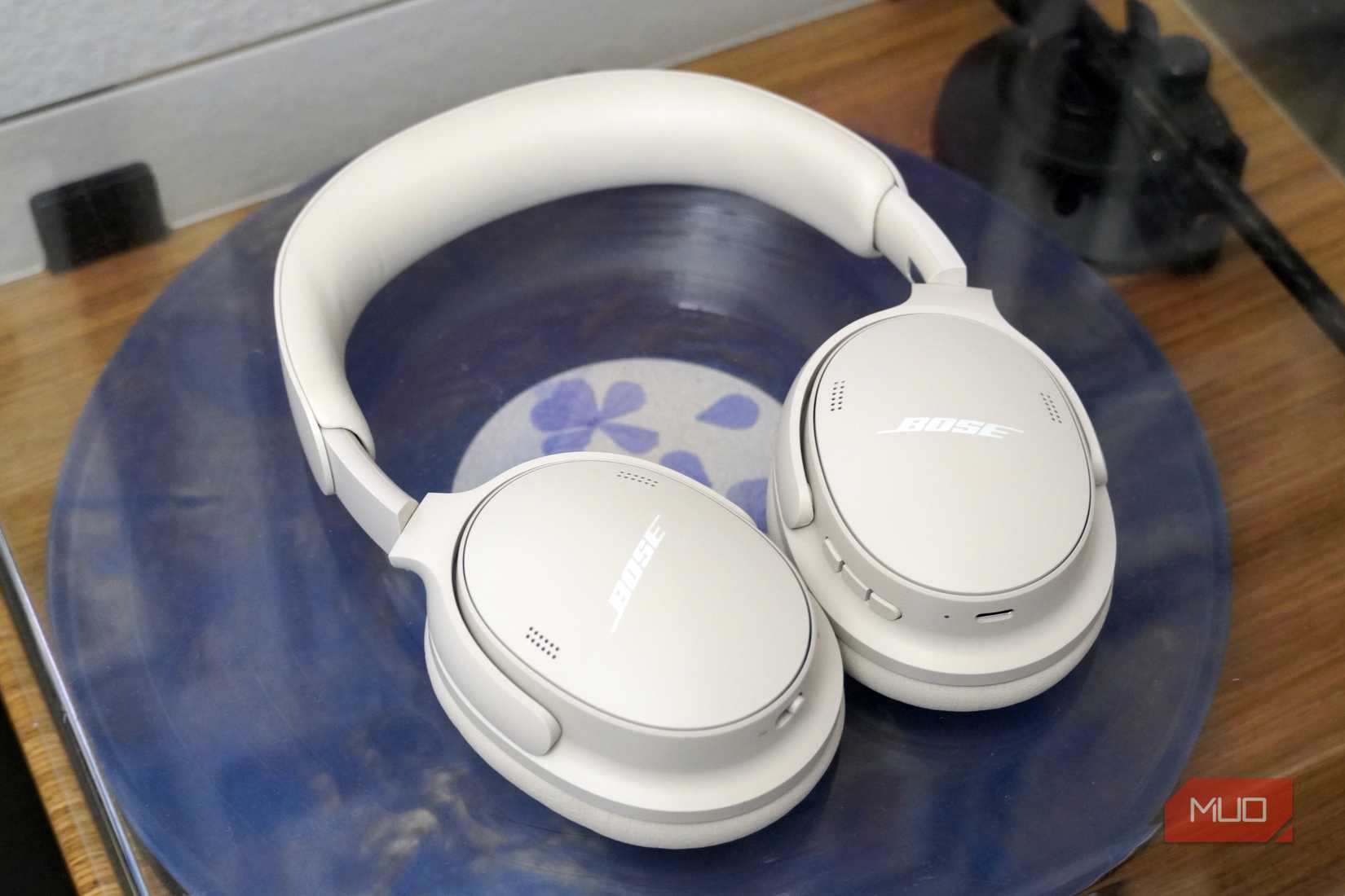 The Bose QuietComfort 2 headphones in white atop a record player.