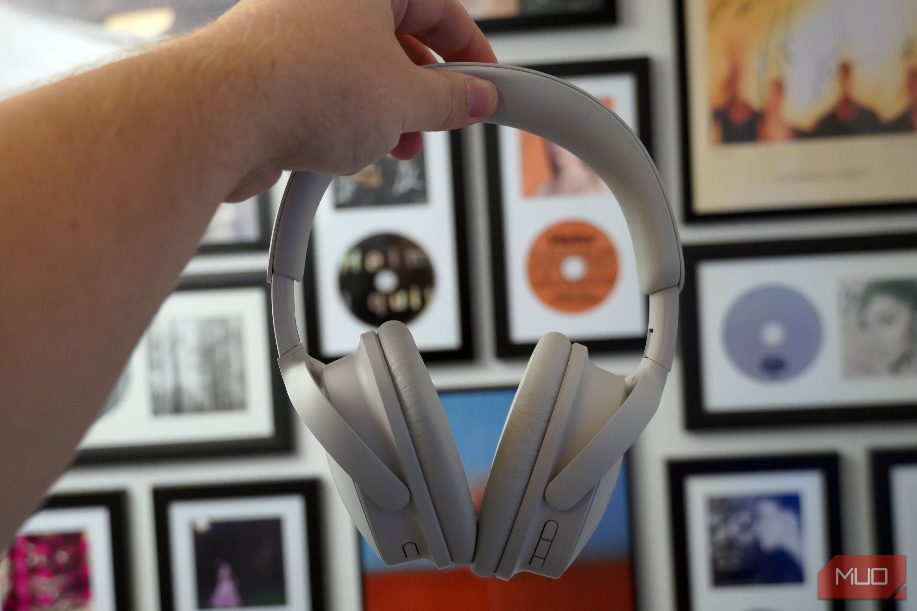 Holding the Bose QuietComfort 2 headphones in white.
