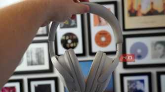 Holding the Bose QuietComfort 2 headphones in white.