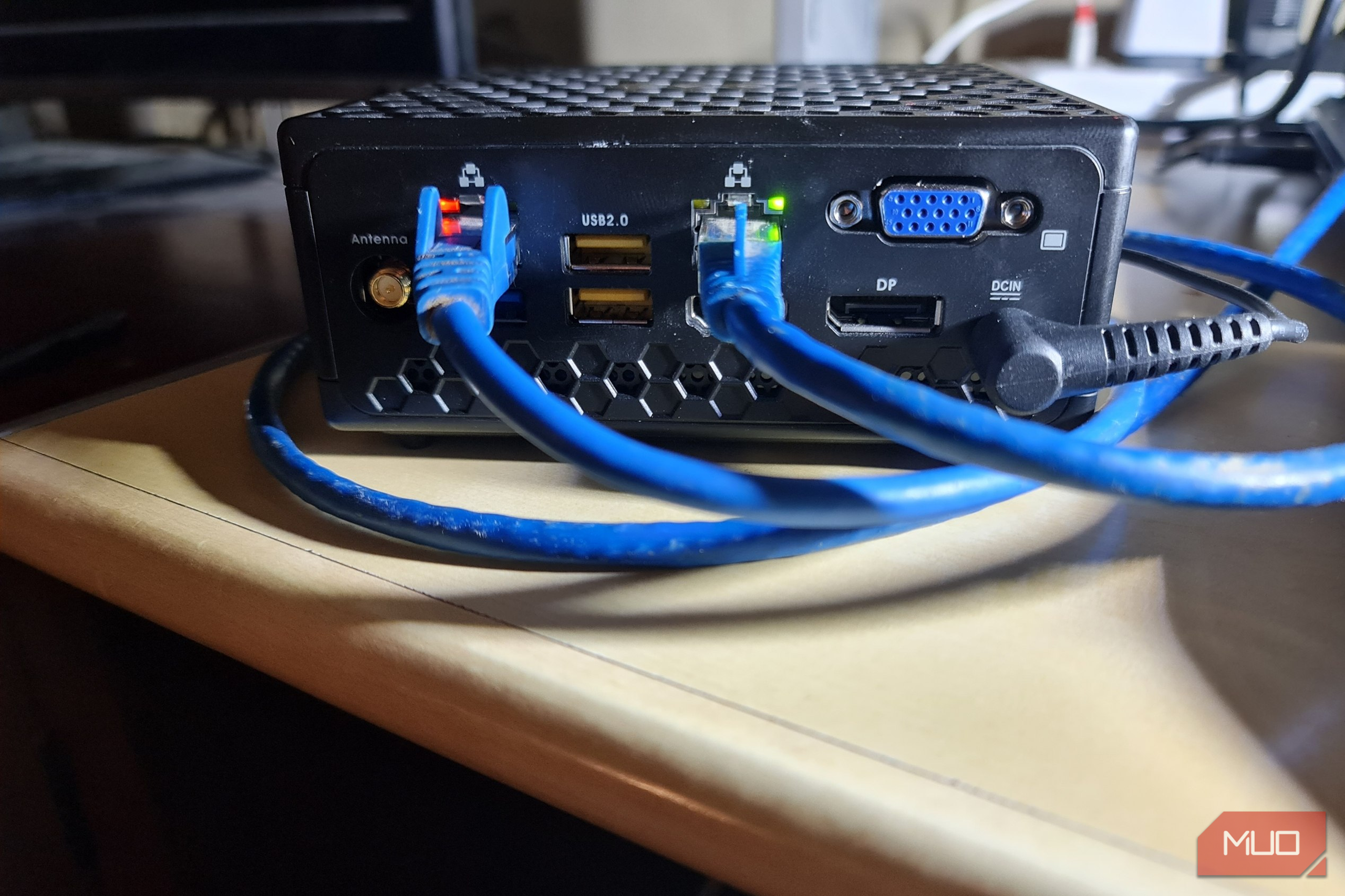Zotac mini PC on a workbench with an Ethernet cable coiled around it