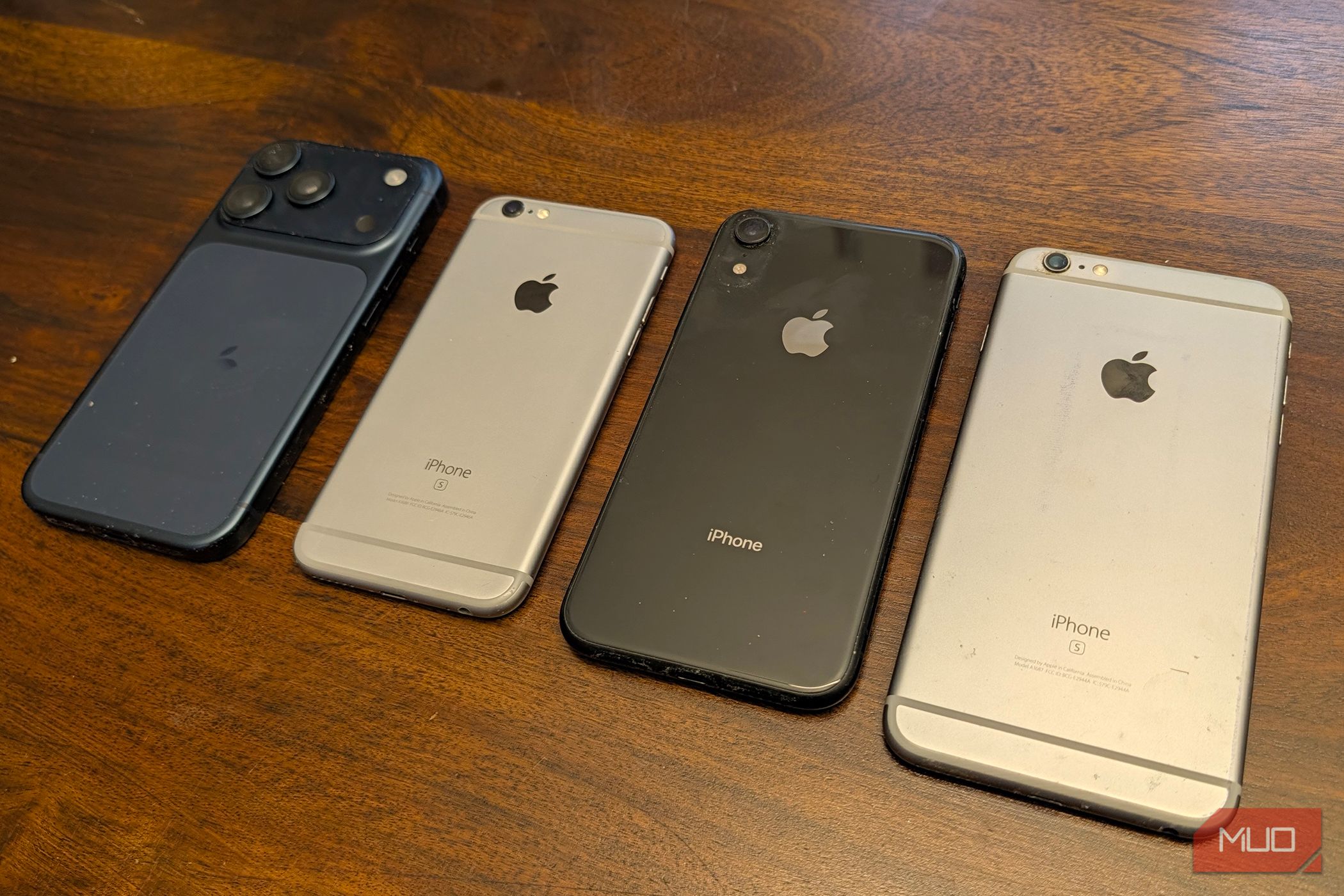 Четыре поколения смартфонов iPhone в ряд на столе