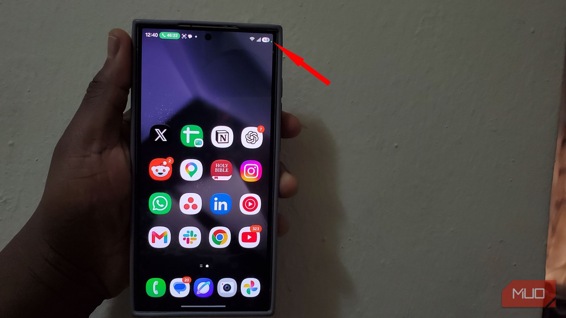 Hand holding smartphone displaying app icons on screen