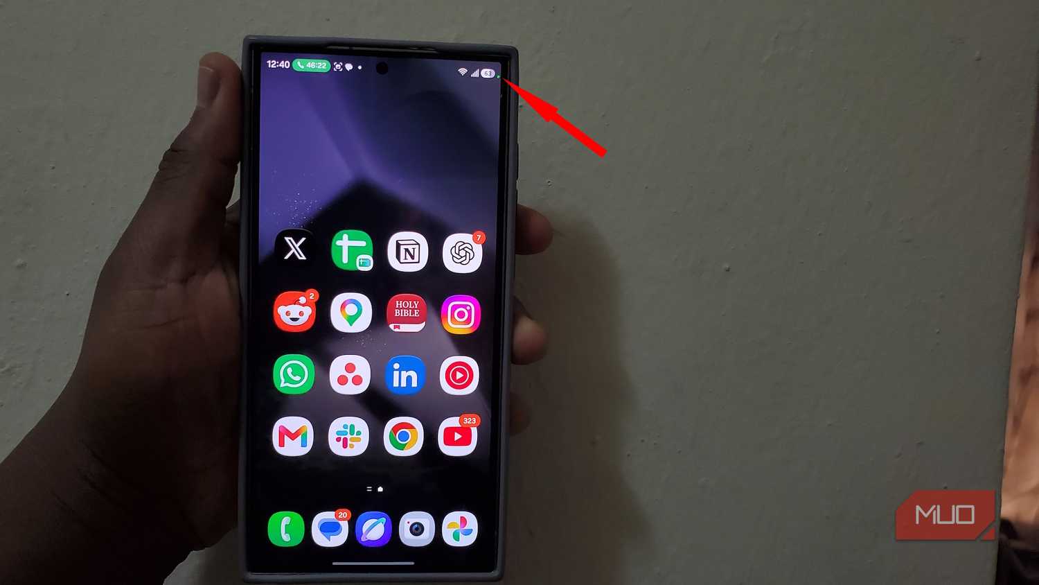 Hand holding smartphone displaying app icons on screen