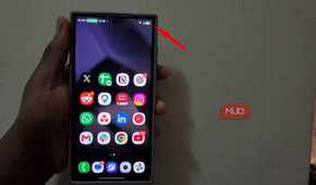 Hand holding smartphone displaying app icons on screen