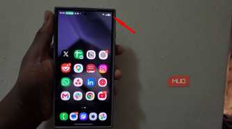Hand holding smartphone displaying app icons on screen