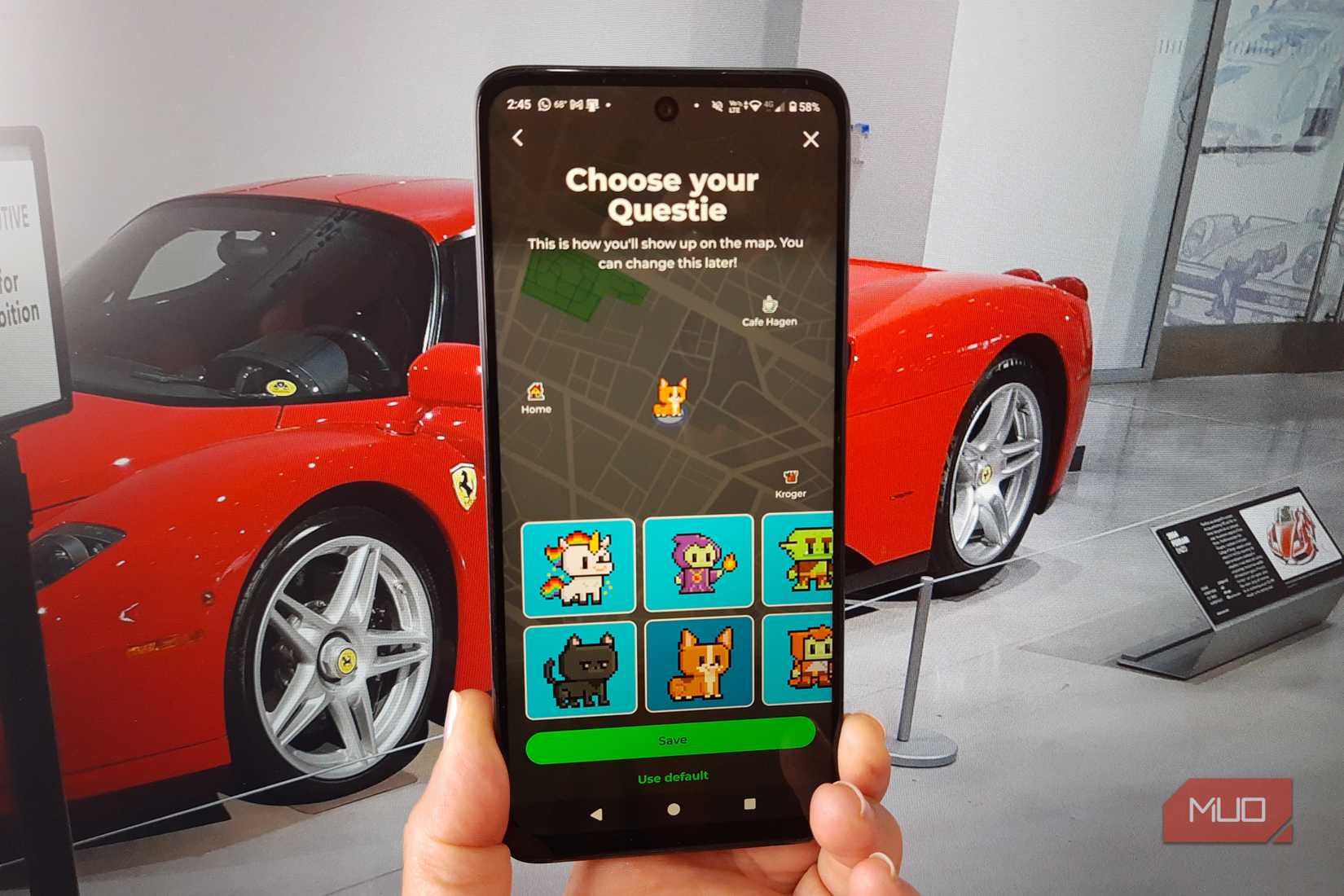 A hand holding a phone showing MapQuest's Questie avatar picker, with a red Ferrari in the background