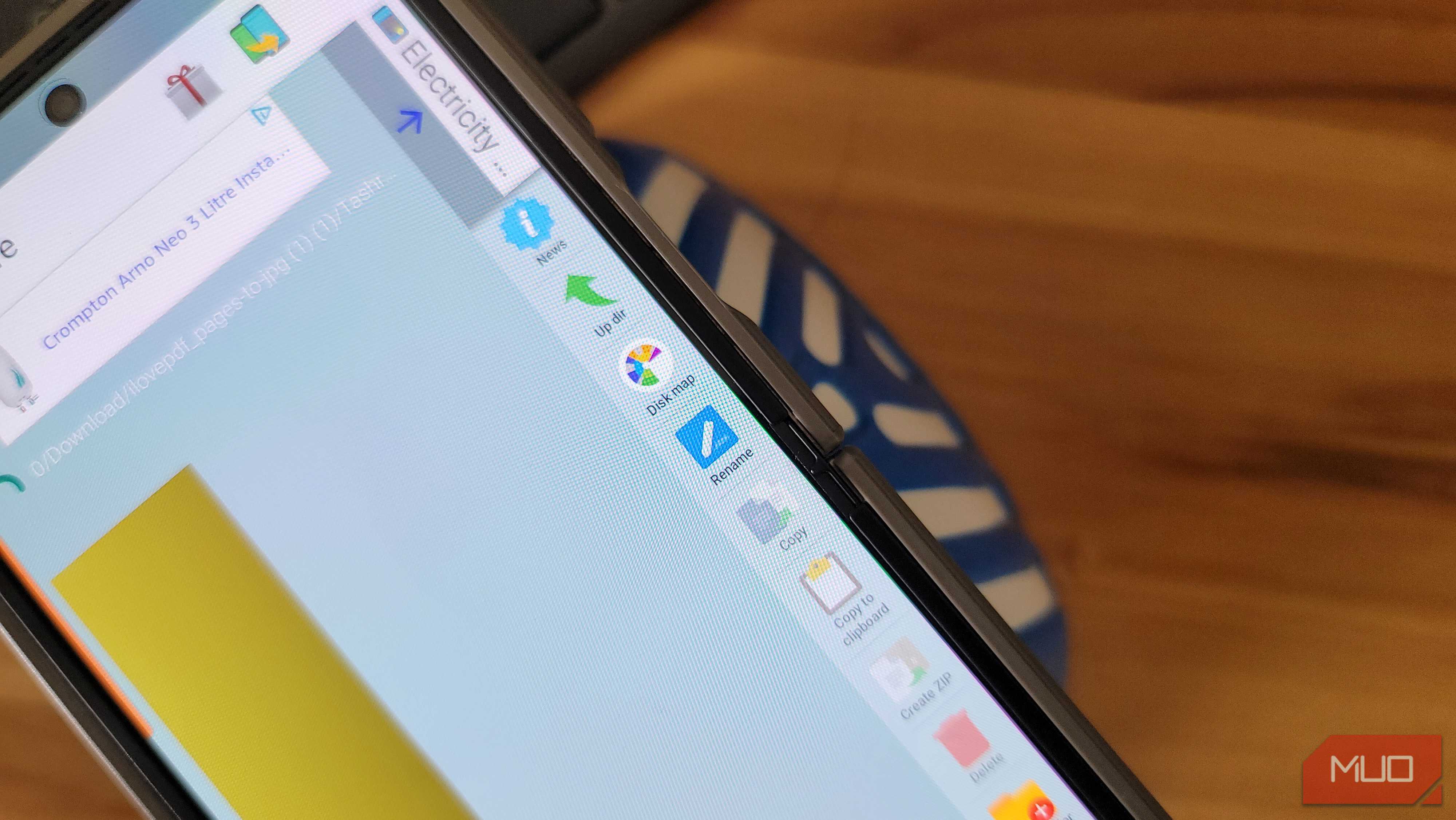 phone file manager showing download folder with action menu on wooden desk