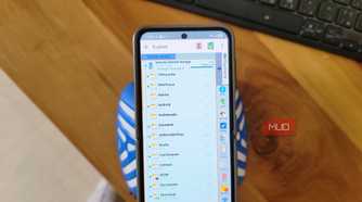 phone showing x plore file manager browsing internal shared storage folders on wooden desk