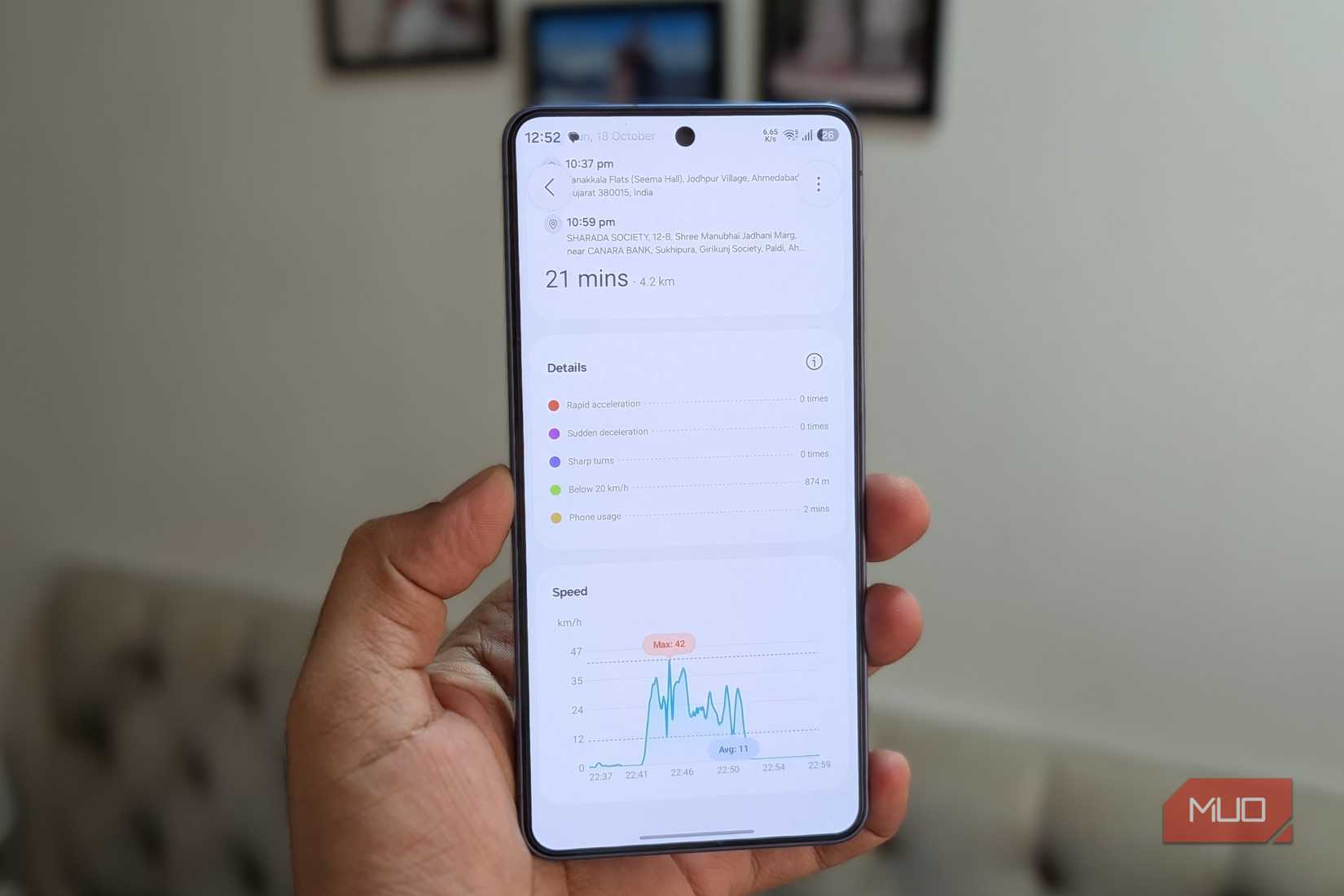Samsung phone in hand showing driving report