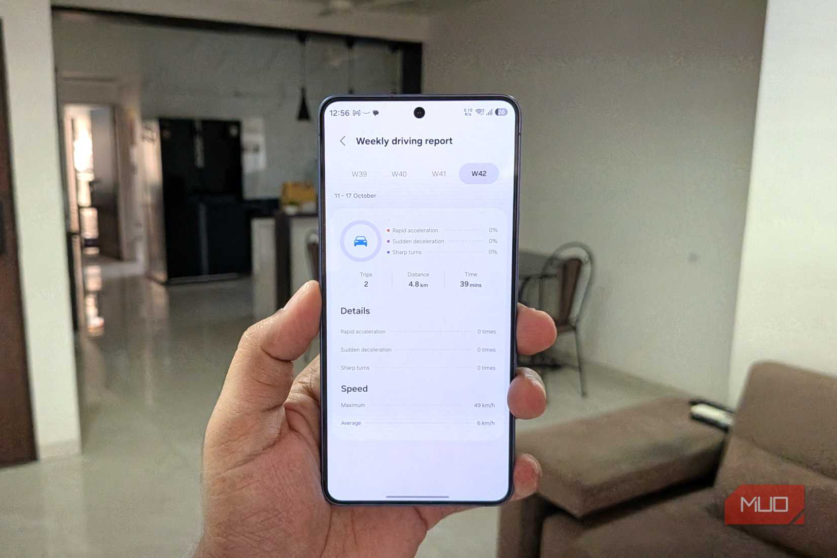 Samsung phone in hand showing driving stats