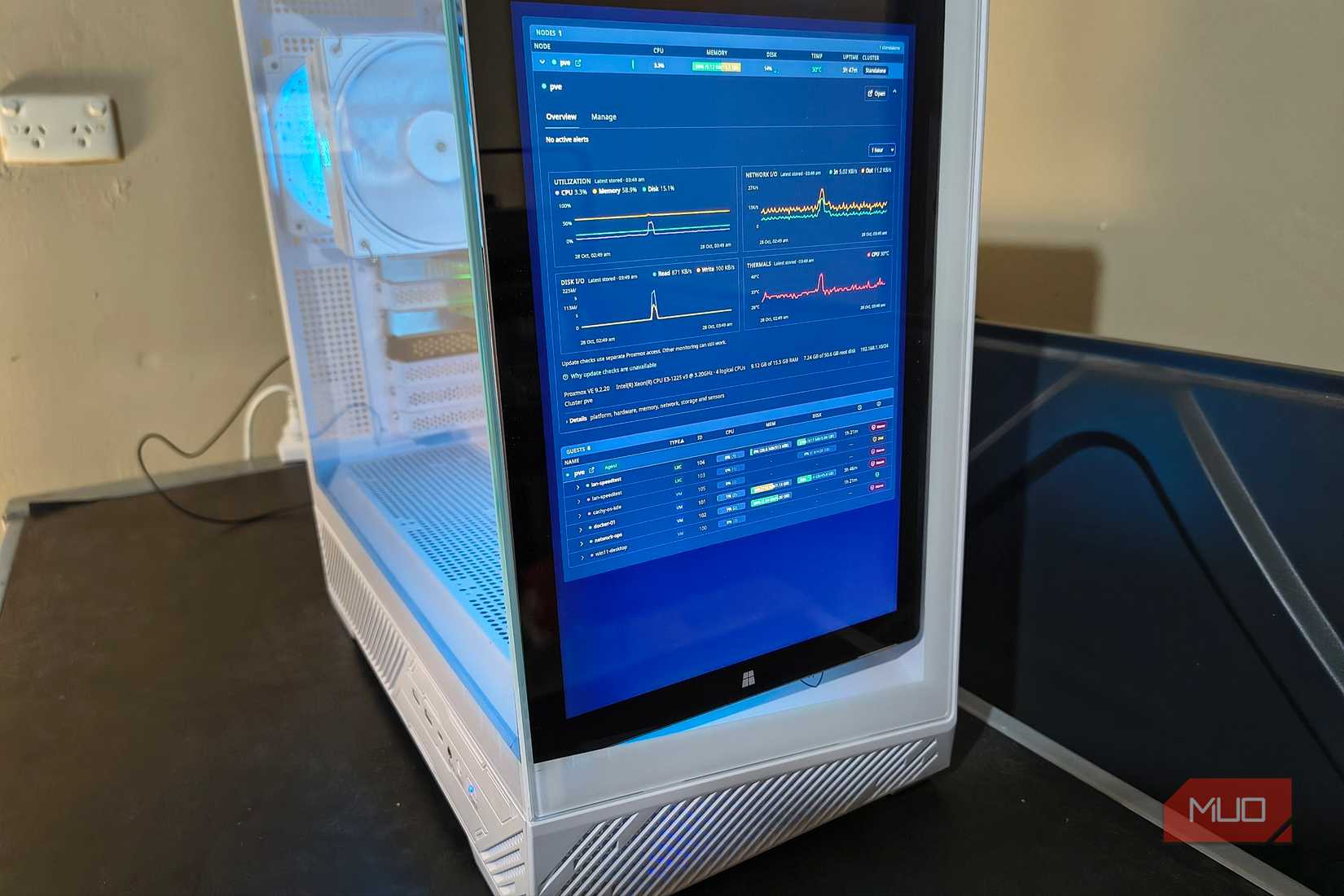 Close-up of my Surface fitted vertically inside the server case, displaying Proxmox resource graphs and virtual machine statistics