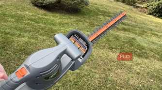 Scotts Corded Hedge Trimmer being held up over grass