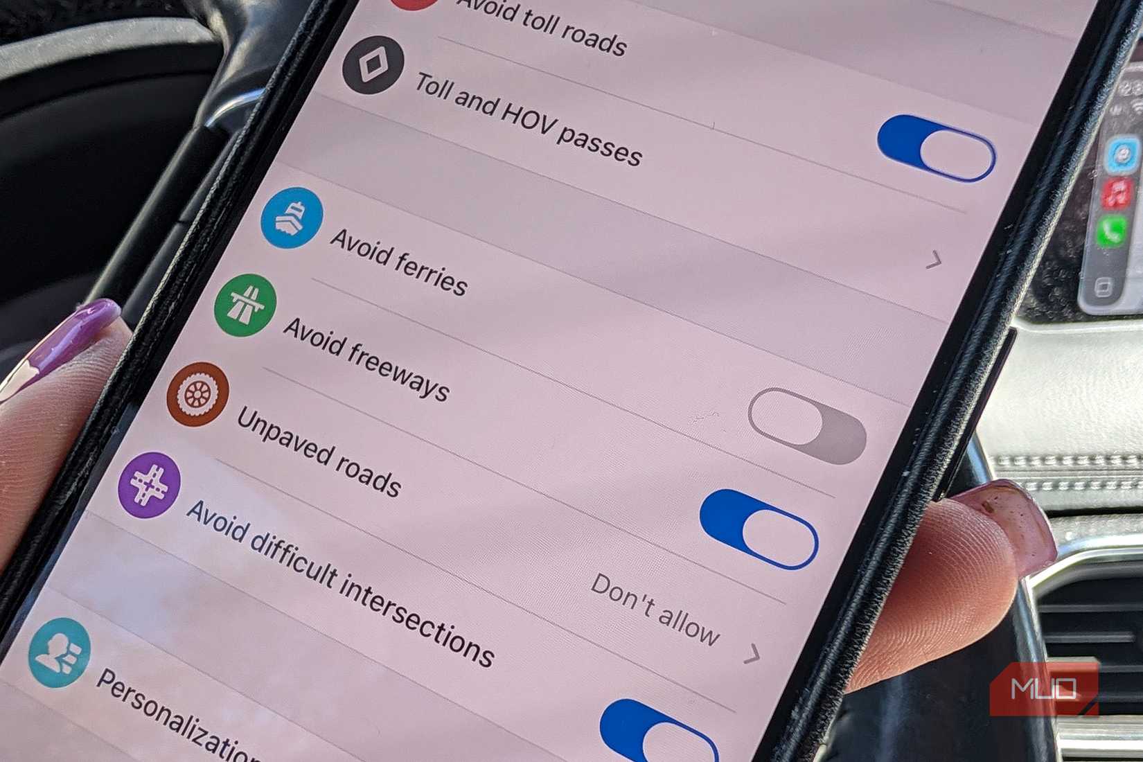 A close-up of an iPhone in a car showing avoid freeways selected for Waze.