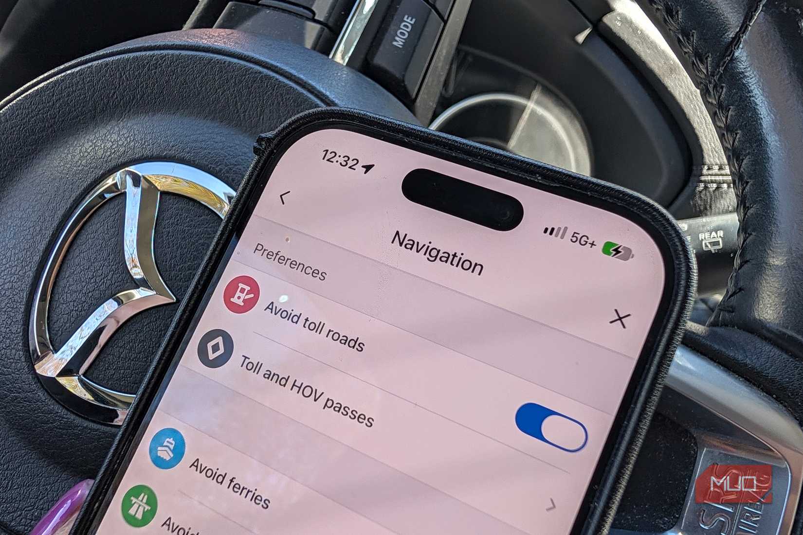 A close-up of an iPhone in a car showing avoid toll roads in Waze.