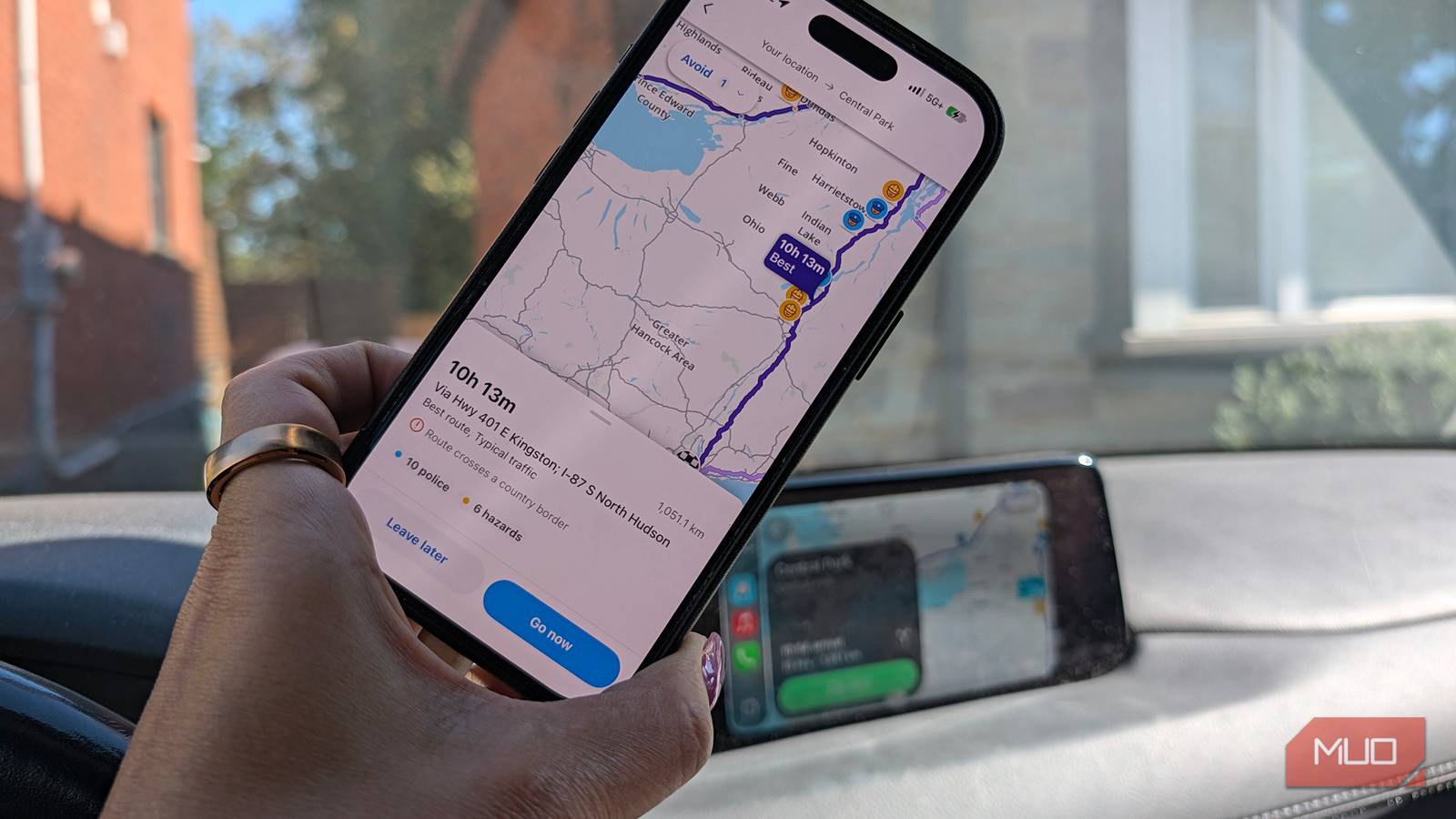 An iPhone in a car showing Waze directions to Central Park.