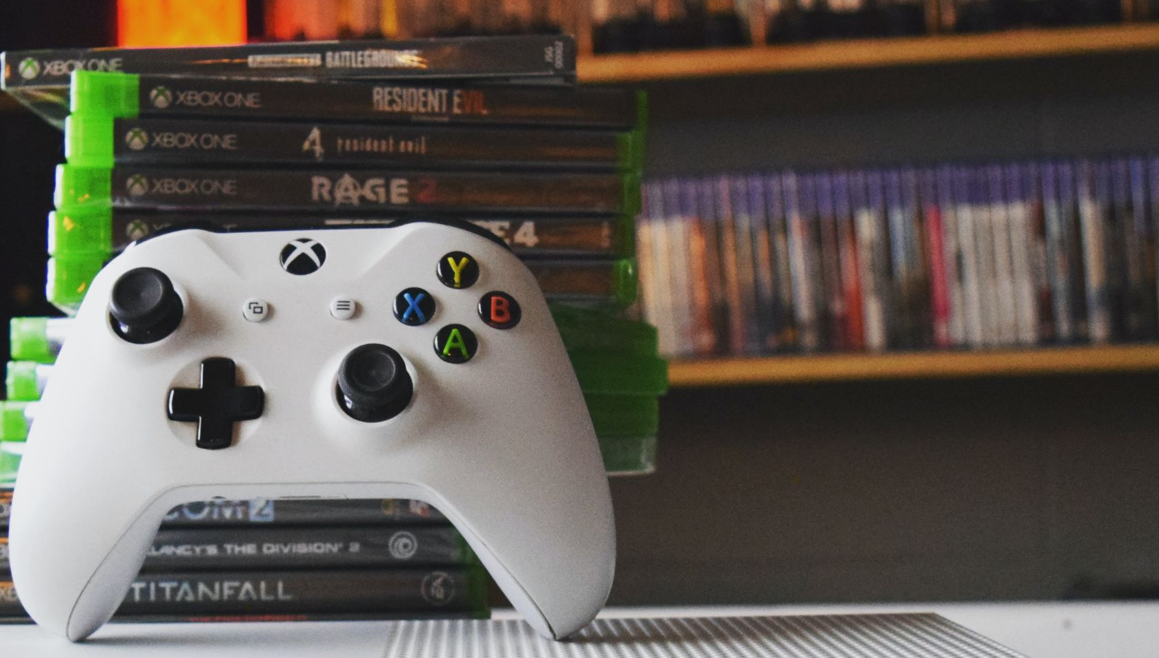 Physische Spiele vs. digitale Spiele: Welche sind am besten zu kaufen? - Xbox controller with Xbox and Playstation video game colleciton